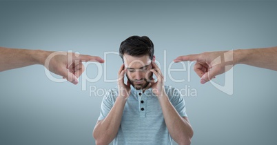 Hands pointing at sad man against blue background