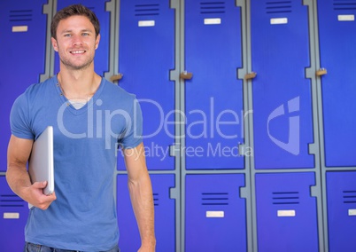 male student holding book in front of lockers