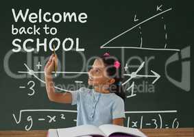 Student girl at table writing against green blackboard with welcome to school text