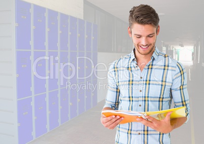 male student holding book in front of lockers