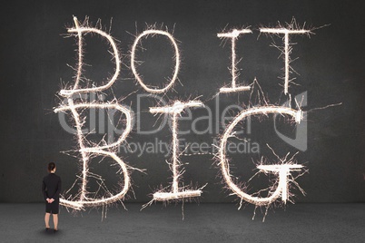 Business woman standing in front of a motivational text