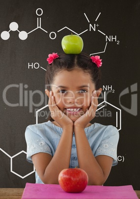 Happy student girl at table against grey blackboard with school and education graphic