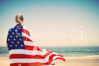 Woman holding a USA flag in the beach