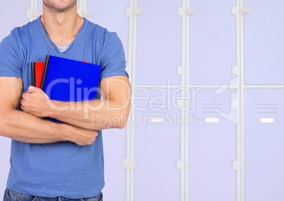 male student holding books in front of lockers