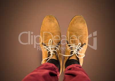 Brown shoes on feet with brown background