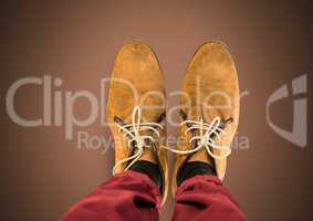 Brown shoes on feet with brown background