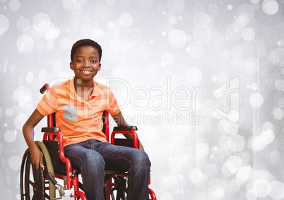 Disabled boy in wheelchair with bright sparkling bokeh background