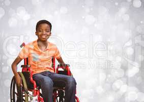 Disabled boy in wheelchair with bright sparkling bokeh background