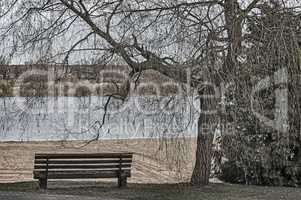 Late autumn on the river: an empty beach and a bench.