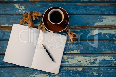 Overhead view of open book by coffee cup