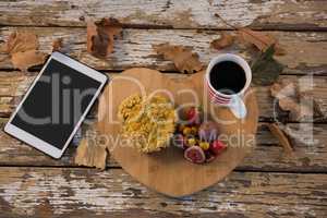 Food with coffee cup on wooden tray by tablet computer