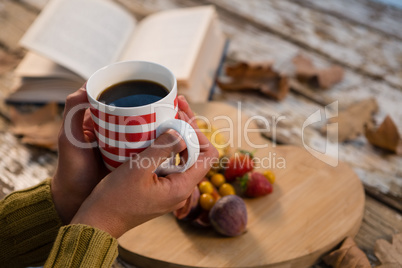 Cropped hand on woman having coffee at table