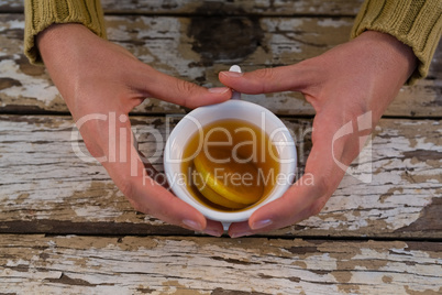 Cropped hand on woman having lemon tea