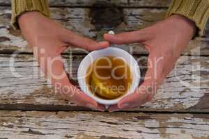 Cropped hand on woman having lemon tea