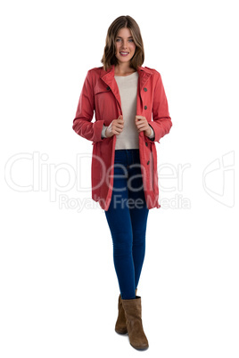 Full length of portrait of smiling young woman wearing warm clothing