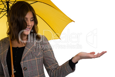 Young woman holding umbrella while gesturing