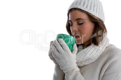 Close up of woman in warm clothing having coffee