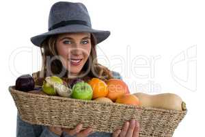 Portrait of young woman holding vegetables in wicker basket