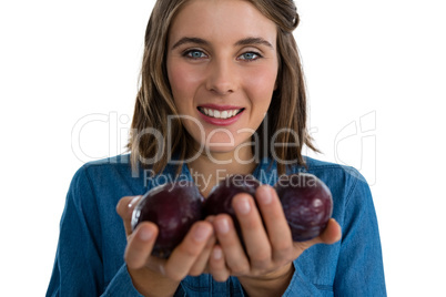 Portrait of young woman holding plums
