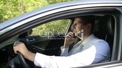 Successful man in car talking on cell phone