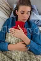 Directly above shot of woman with hot water bottle while sleeping