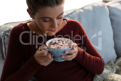 High angle view of young woman having hot chocolate