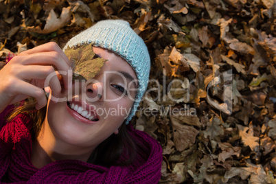 Directly above portrait of woman lying on dry leaves