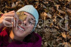 Directly above portrait of woman lying on dry leaves