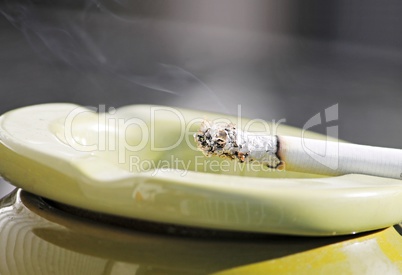 brennende Zigarette im Aschenbecher
