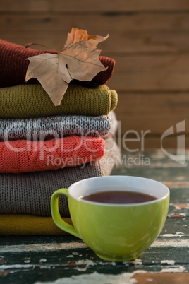 Close up of cup by stacked sweaters