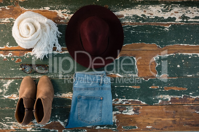 Overhead view of scarf and jeans with personal accessories