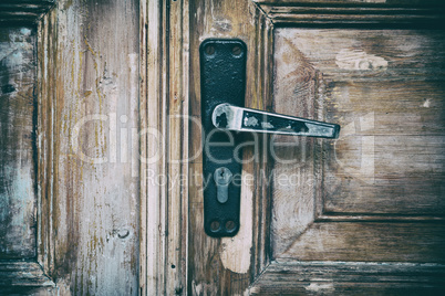 wooden door with an iron lock and an iron handle