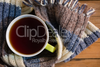 Overhead view of black coffee amidst scarf