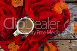 Overhead view of coffee cup amidst scarf