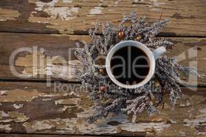 Overhead view of black coffee on dried plant