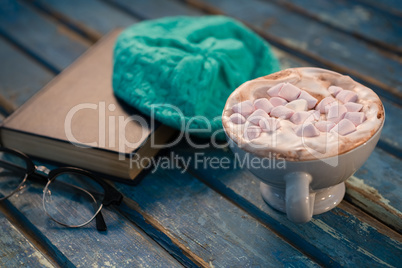 Close up of hot chocolate by cap and book