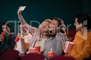 Friends taking a selfie while watching movie