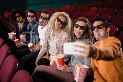 Friends taking a selfie while watching movie