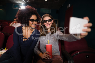 Friends taking a selfie while watching movie