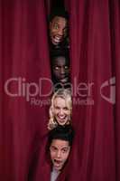 Actors hiding behind stage curtains