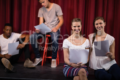 Actors reading their scripts on stage