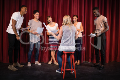 Actors reading their scripts on stage