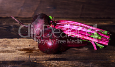Two whole fresh beets with a tops
