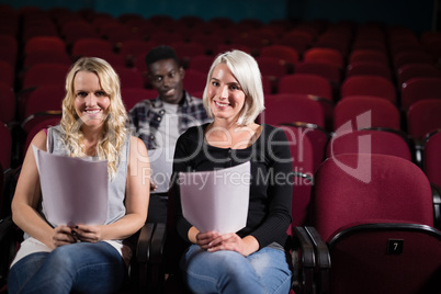 Actors reading their scripts on stage in theatre