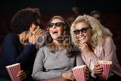 Female friends gossiping while watching movie