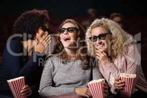 Female friends gossiping while watching movie