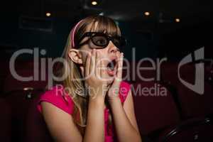 Surprised girl wearing 3D glasses while watching movie