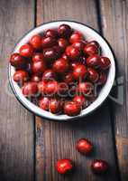 Ripe red cherry in an iron bowl