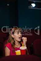 Girl having popcorns and drink while watching movie