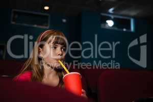 Girl having drink while watching movie